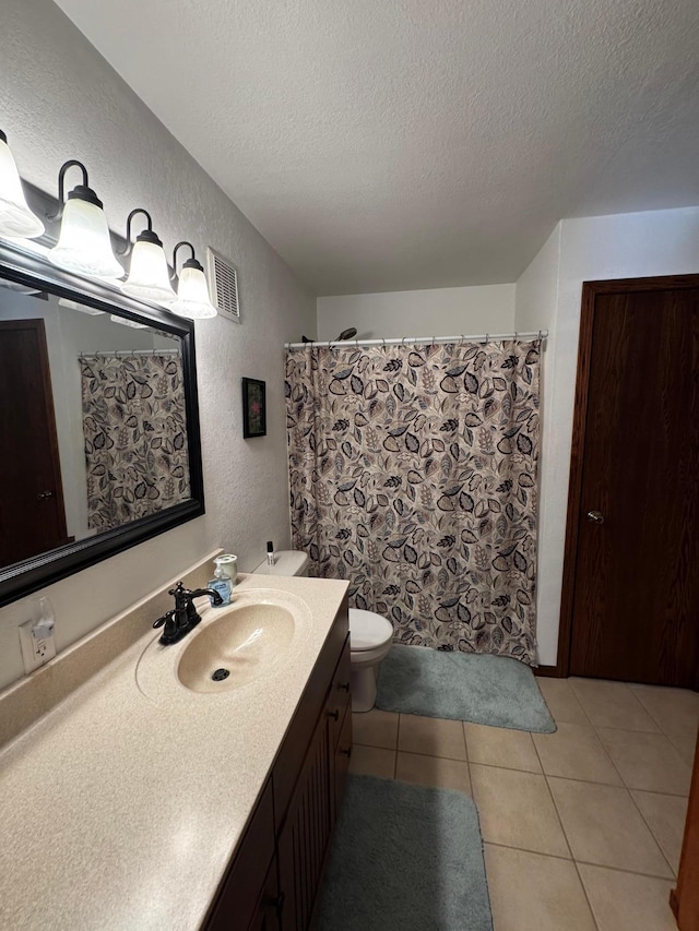 full bathroom with tile patterned flooring, visible vents, a textured wall, and a textured ceiling