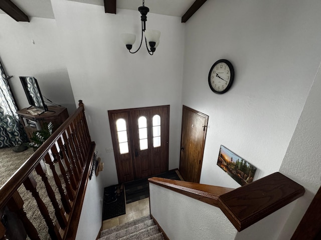 entryway with stairway, beam ceiling, and a notable chandelier