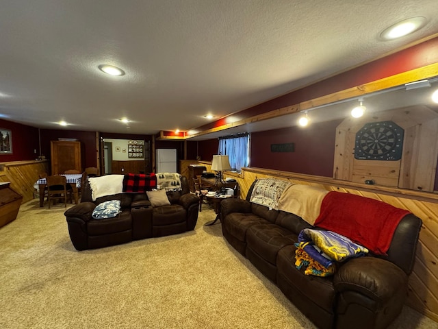 carpeted cinema room with wood walls, a textured ceiling, and recessed lighting