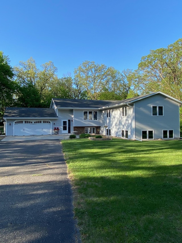 8673 Decathelon Dr, Spicer, MN 56288 - view of front of home featuring asphalt driveway, a garage, and a front lawn
