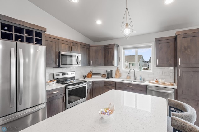 kitchen with lofted ceiling, stainless steel appliances, tasteful backsplash, and a sink