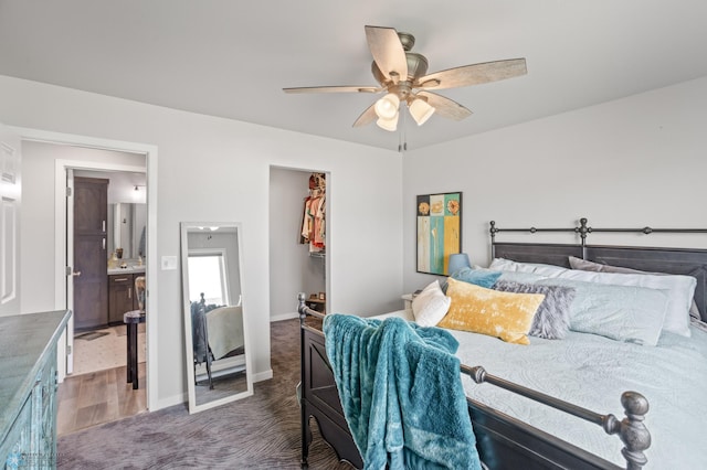 bedroom with carpet, a closet, a spacious closet, ceiling fan, and baseboards