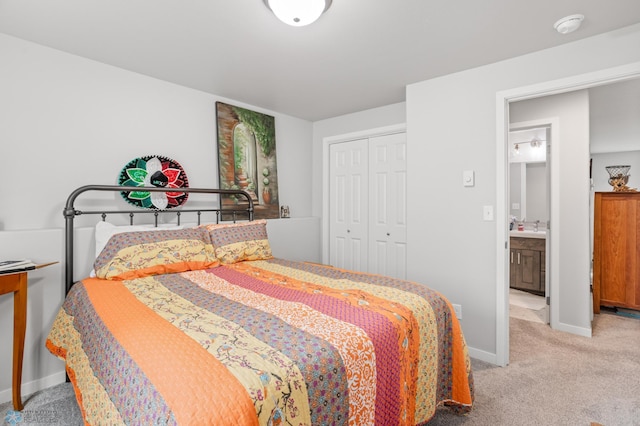 bedroom featuring baseboards, a closet, a sink, and light colored carpet