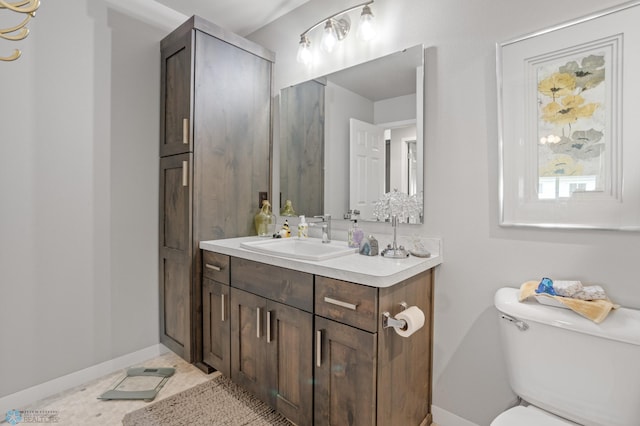 bathroom featuring tile patterned flooring, vanity, toilet, and baseboards