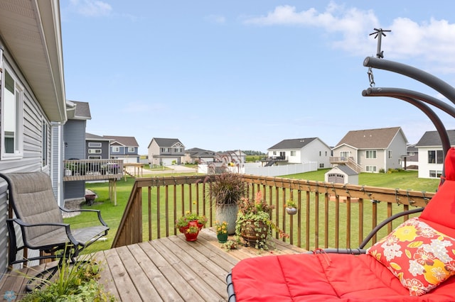 wooden terrace with a residential view and a yard