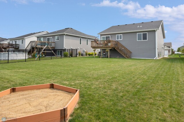 rear view of house with a yard, fence, stairway, and a wooden deck