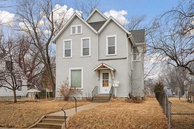 traditional-style home featuring roof with shingles and fence