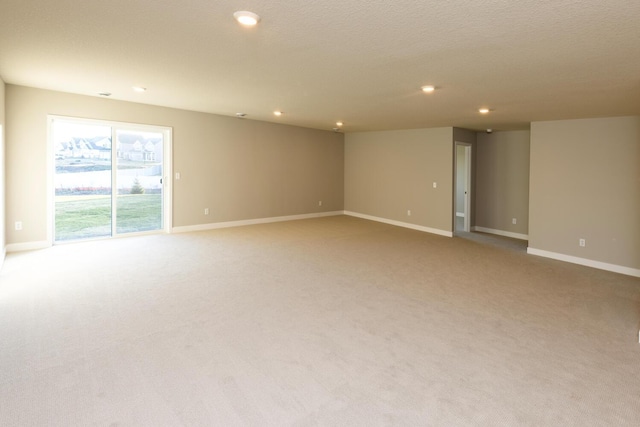 empty room featuring baseboards, recessed lighting, and light colored carpet