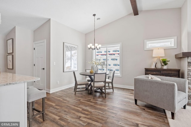 dining room featuring a notable chandelier, lofted ceiling with beams, baseboards, and wood finished floors