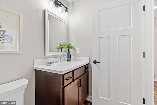 half bath featuring toilet and vanity