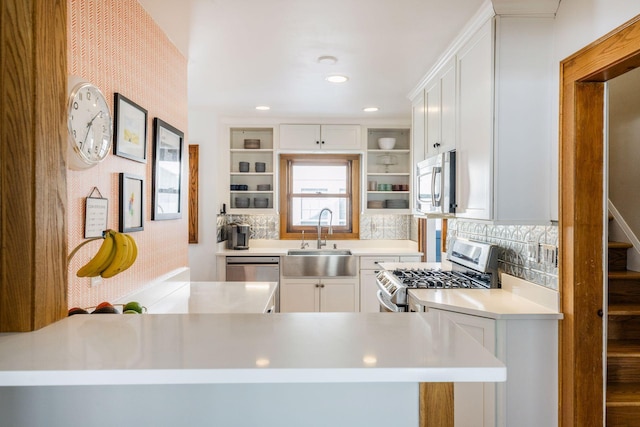 kitchen featuring open shelves, white cabinets, stainless steel appliances, and a sink