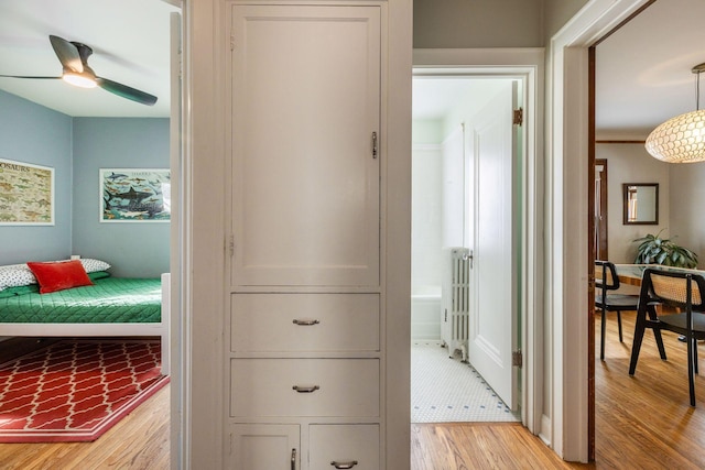 hallway with light wood-type flooring and radiator heating unit