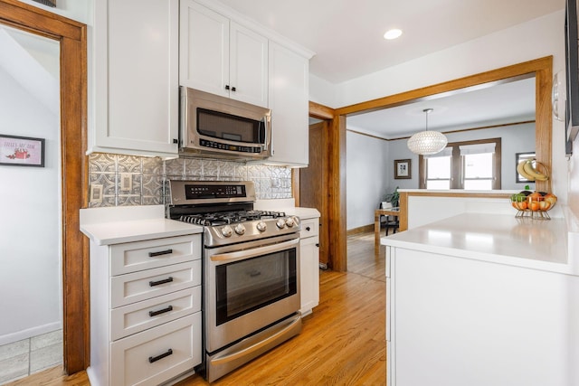 kitchen featuring stainless steel appliances, white cabinets, light countertops, decorative backsplash, and light wood finished floors