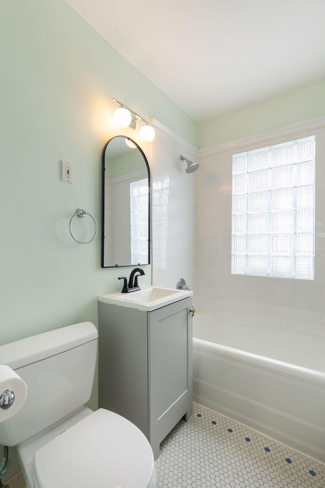 full bath with washtub / shower combination, tile patterned flooring, vanity, and toilet