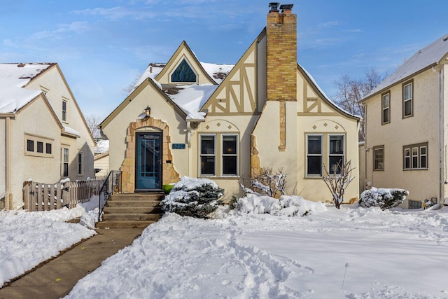 tudor home featuring a chimney and stucco siding