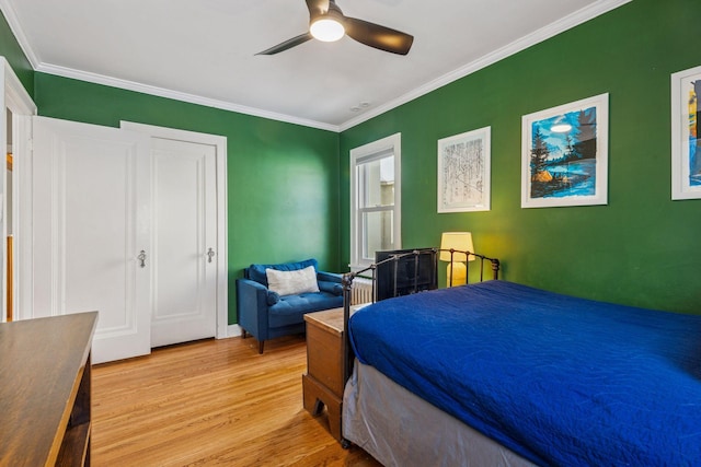 bedroom with ornamental molding, light wood finished floors, and a ceiling fan