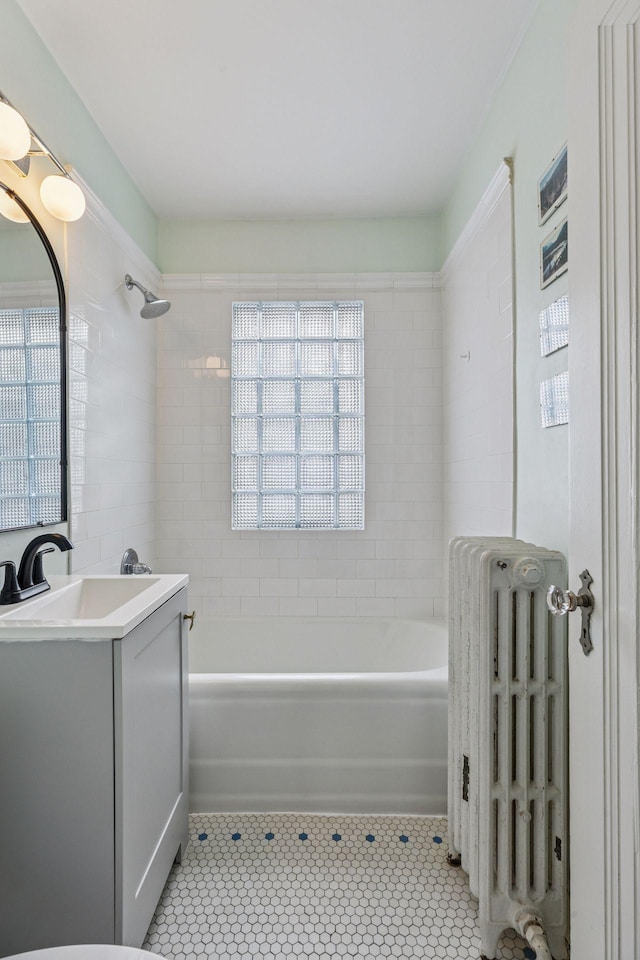 full bathroom with washtub / shower combination, tile patterned flooring, radiator, and vanity