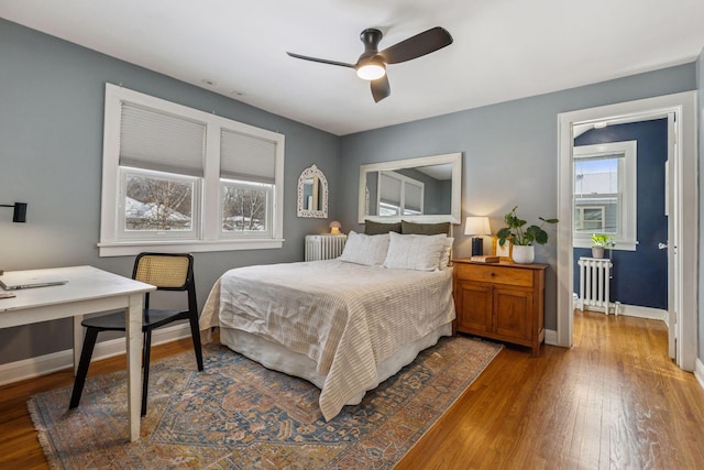 bedroom with radiator, wood-type flooring, and baseboards