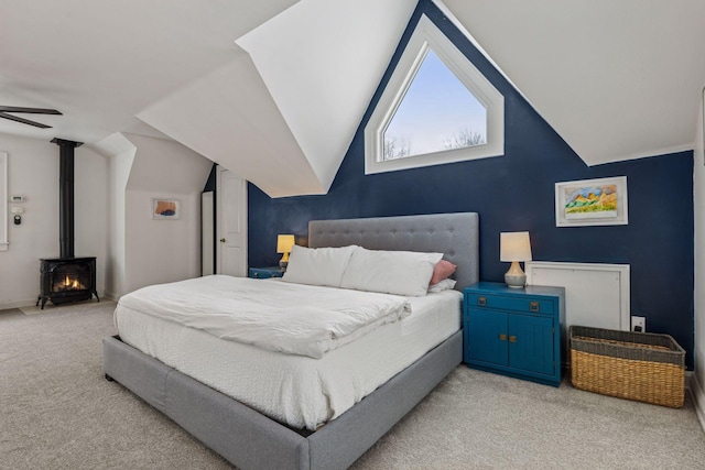 bedroom featuring carpet, a wood stove, and vaulted ceiling