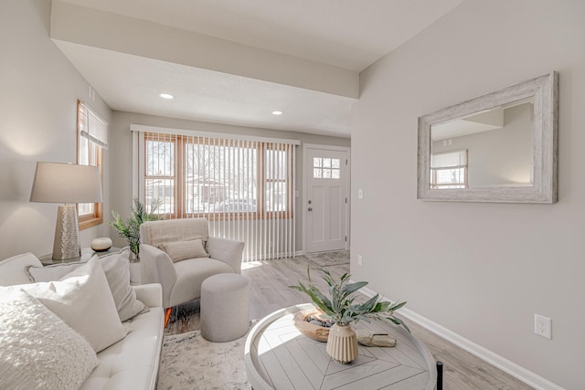 living area featuring a healthy amount of sunlight, baseboards, wood finished floors, and recessed lighting