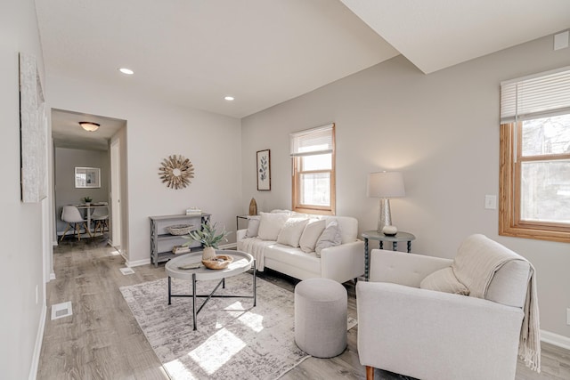 living room featuring light wood-style flooring, recessed lighting, a wealth of natural light, and baseboards