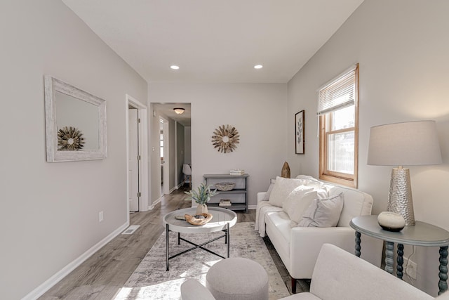 living area with light wood-style floors, baseboards, and recessed lighting