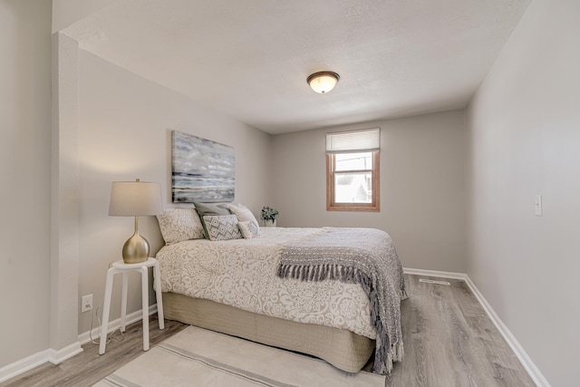 bedroom with wood finished floors and baseboards