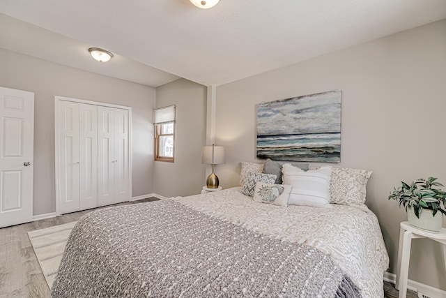 bedroom featuring a closet, baseboards, and wood finished floors