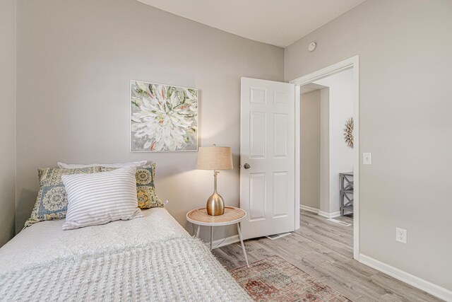 bedroom with baseboards and wood finished floors