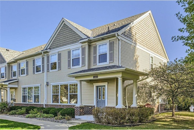 view of front of house featuring brick siding and a shingled roof