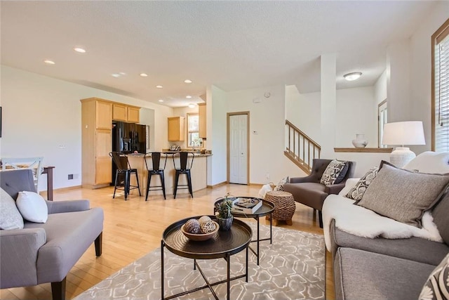 living room with visible vents, stairway, a textured ceiling, light wood-type flooring, and recessed lighting