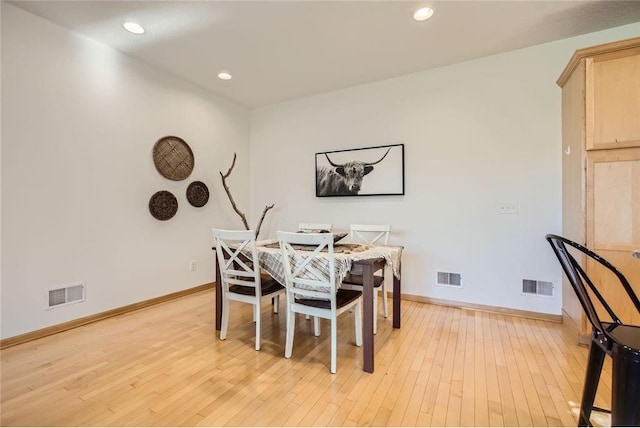 dining room with visible vents, light wood-style flooring, and baseboards