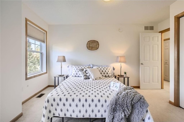 bedroom featuring light colored carpet, visible vents, and baseboards