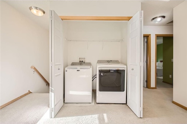 washroom featuring laundry area, baseboards, and separate washer and dryer