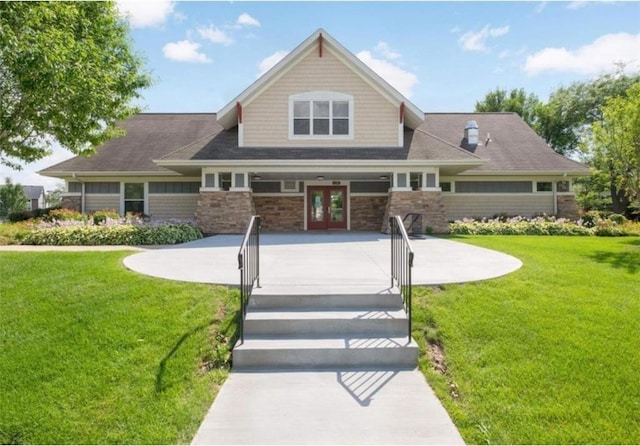 view of front of house with stone siding, a front lawn, a patio, and french doors