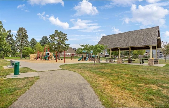 view of community featuring playground community, a lawn, and a gazebo