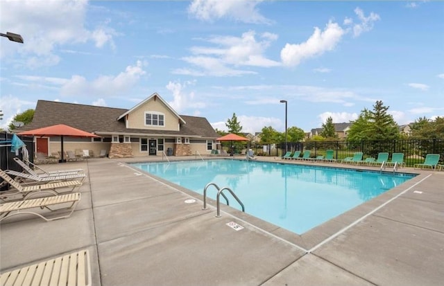 community pool featuring a patio area and fence