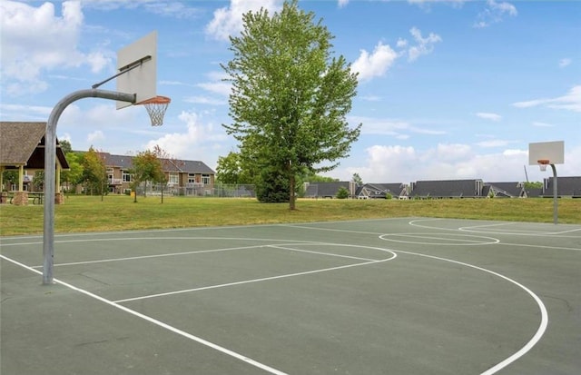 view of sport court featuring community basketball court, fence, and a yard