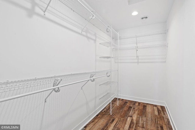 walk in closet featuring dark wood-style flooring and visible vents