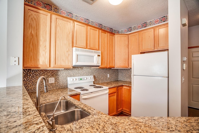 kitchen with backsplash, a sink, a textured ceiling, light stone countertops, and white appliances