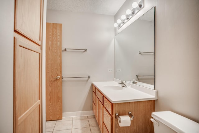 half bath with baseboards, toilet, tile patterned floors, a textured ceiling, and vanity