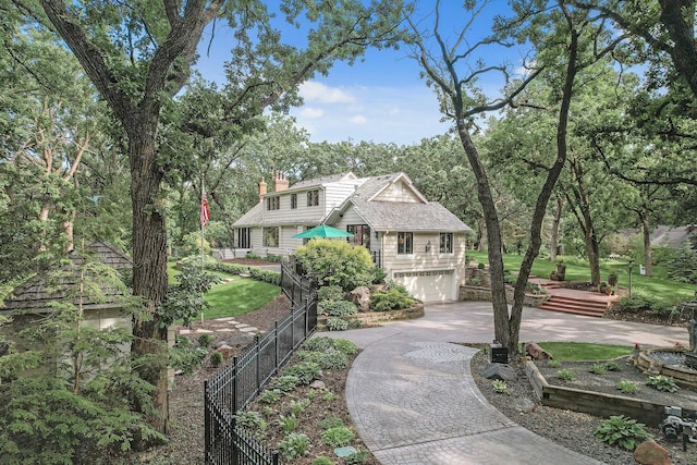 view of front of home featuring a garage, decorative driveway, a chimney, and fence