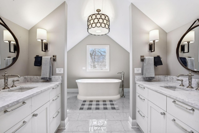10 Saint Albans Rd E, Hopkins, MN 55305 - bathroom featuring lofted ceiling, marble finish floors, baseboards, two vanities, and a freestanding tub