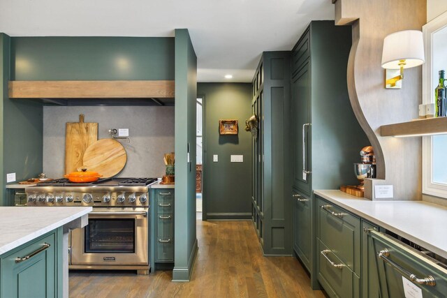10 Saint Albans Rd E, Hopkins, MN 55305 - kitchen featuring green cabinetry, stainless steel stove, dark wood-style floors, light countertops, and wall chimney range hood