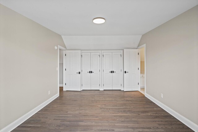 10 Saint Albans Rd E, Hopkins, MN 55305 - unfurnished bedroom featuring vaulted ceiling, multiple closets, baseboards, and dark wood finished floors
