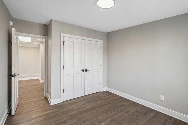 10 Saint Albans Rd E, Hopkins, MN 55305 - unfurnished bedroom featuring dark wood-style flooring, baseboards, and a closet