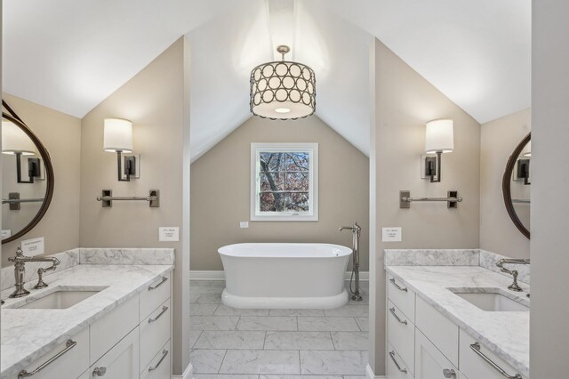 10 Saint Albans Rd E, Hopkins, MN 55305 - bathroom with marble finish floors, vaulted ceiling, a soaking tub, two vanities, and baseboards