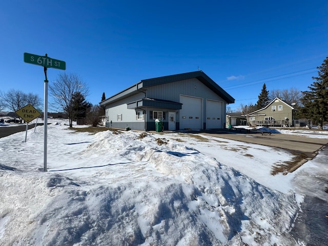 view of snow covered exterior with a garage