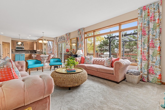 living area featuring recessed lighting, carpet, and a chandelier