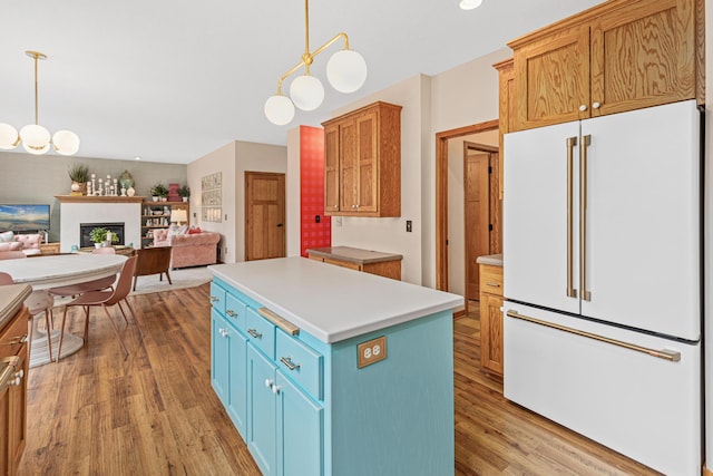 kitchen featuring light wood-style floors, white refrigerator, open floor plan, and light countertops